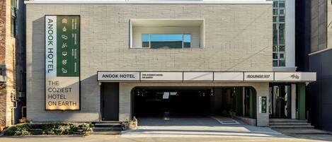 A hotel entrance with a sign for 'Anook Hotel' and 'The Coziest Hotel on Earth.'