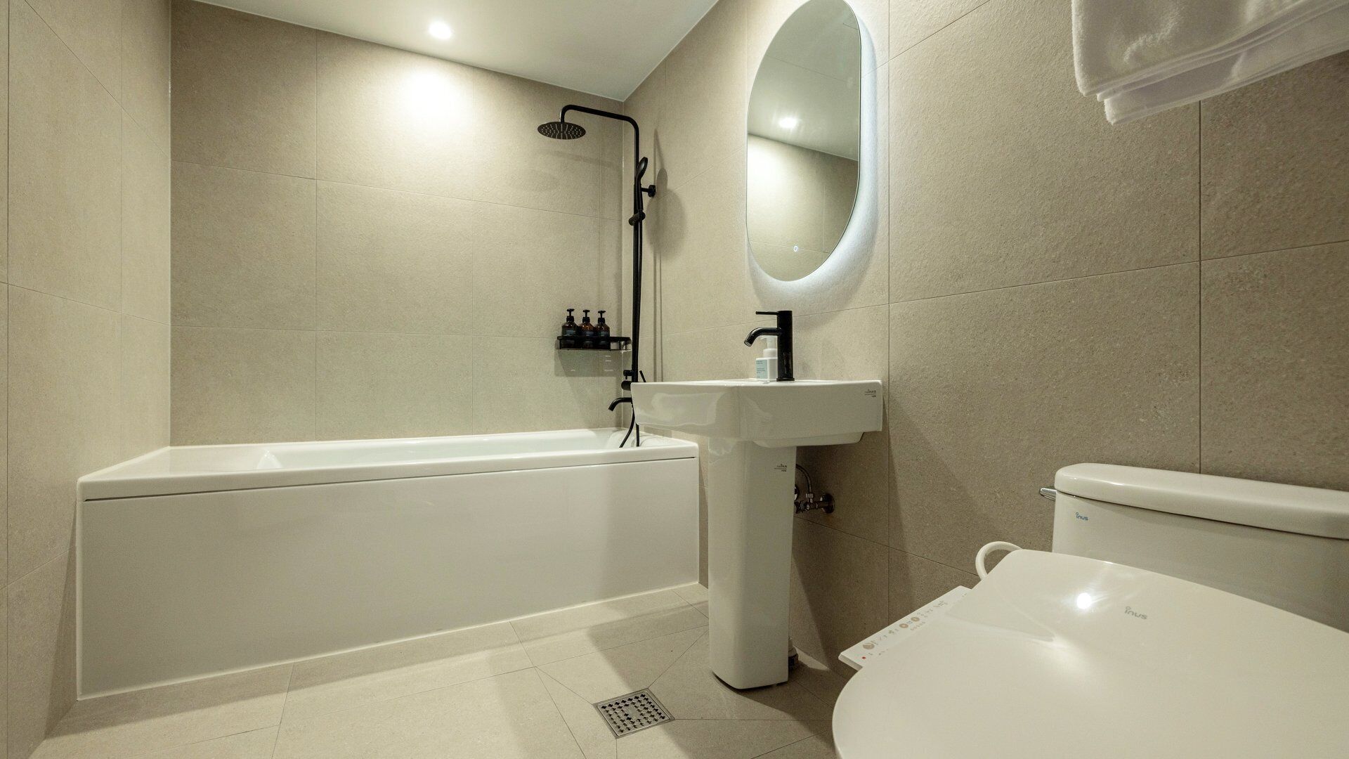 A modern bathroom with a bathtub, a sink, and a toilet.