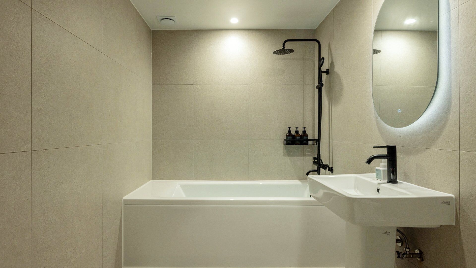 A modern bathroom with a bathtub, a sink, and a shower.