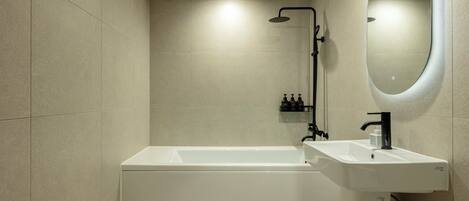 A modern bathroom with a bathtub, a sink, and a shower.