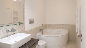 Un baño con lavamanos, inodoro y bañera blancos.