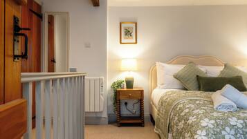 A bedroom with a bed, bedside lamp, and a framed picture on the wall.