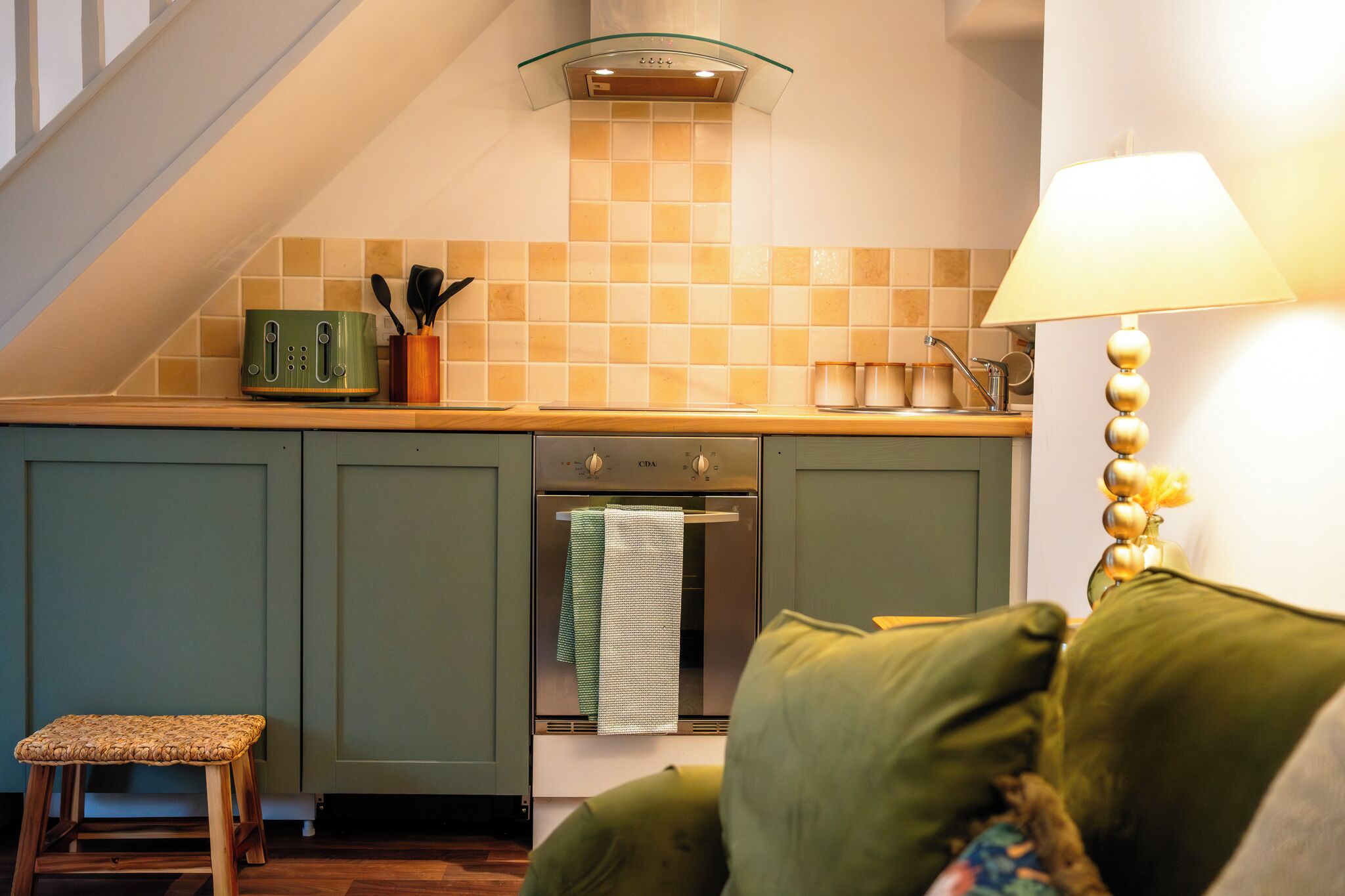 A kitchen with a toaster, oven, and a lamp.