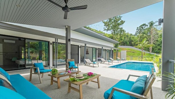 A modern outdoor living area with a pool, seating, and a view of the surrounding greenery. - Wantana villa Sawaree villa 1 V308 (Chang Wat Surat Thani)