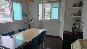 Un comedor con una mesa, sillas y una lámpara colgante.
