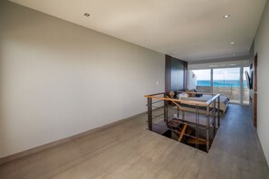 Ein geräumiges Zimmer mit Holzboden, einer Treppe und Meerblick.