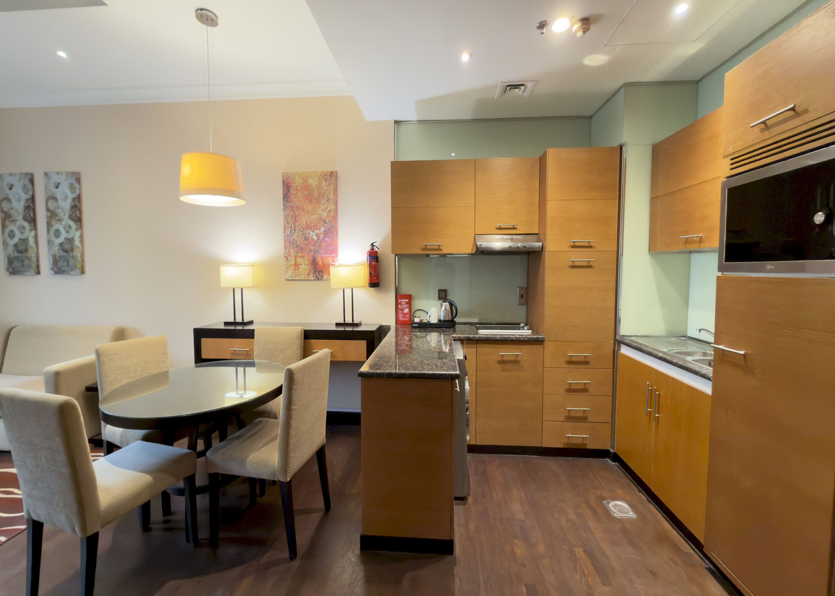 Een moderne keuken met houten kastjes, een centraal eiland en een zithoek met stoelen.