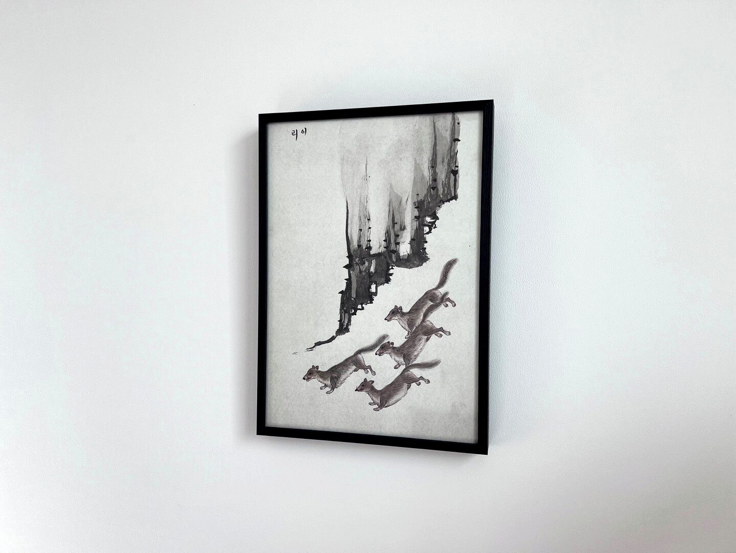 Una obra de arte enmarcada con elementos abstractos y una pequeña inscripción.