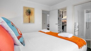 Habitación de hotel con cama, ducha y vestidor.