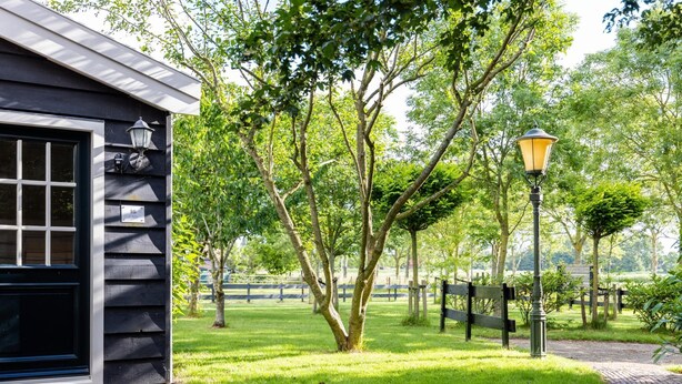 A building with a black exterior, a window with a grid pattern, and a number plaque. - Fantastic family home with large garden (Hippolytushoef)