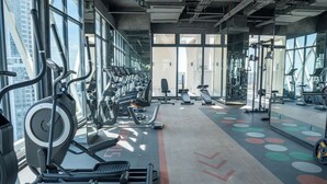 A gym with exercise equipment, large windows, and a concrete floor. - MERIDIAN Inn RESIDENCE  (Phnom Penh)