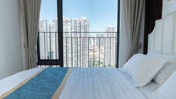 Habitación de hotel con una cama grande, vistas a rascacielos y un balcón.