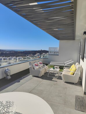 A rooftop terrace with a view of the city, modern outdoor furniture, and a pergola structure. - Casa Seabre (Finestrat)