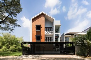 Um edifício moderno com uma placa indicando 'cove', entrada coberta e acesso por portão fechado.