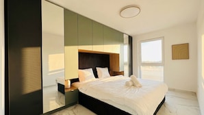 A modern bedroom with a large bed, a nightstand, a mirror, and a window with a view. - Elegant 4BR Villa w/ Garden & Terrace (Mödling)