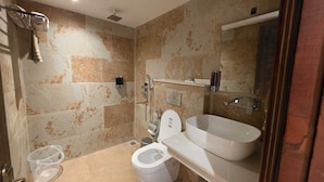 Un baño con inodoro, bidé y un lavamanos grande.