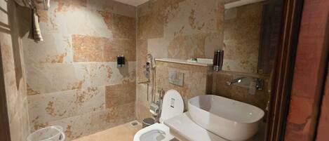 A bathroom with a toilet, bidet, and a large sink.