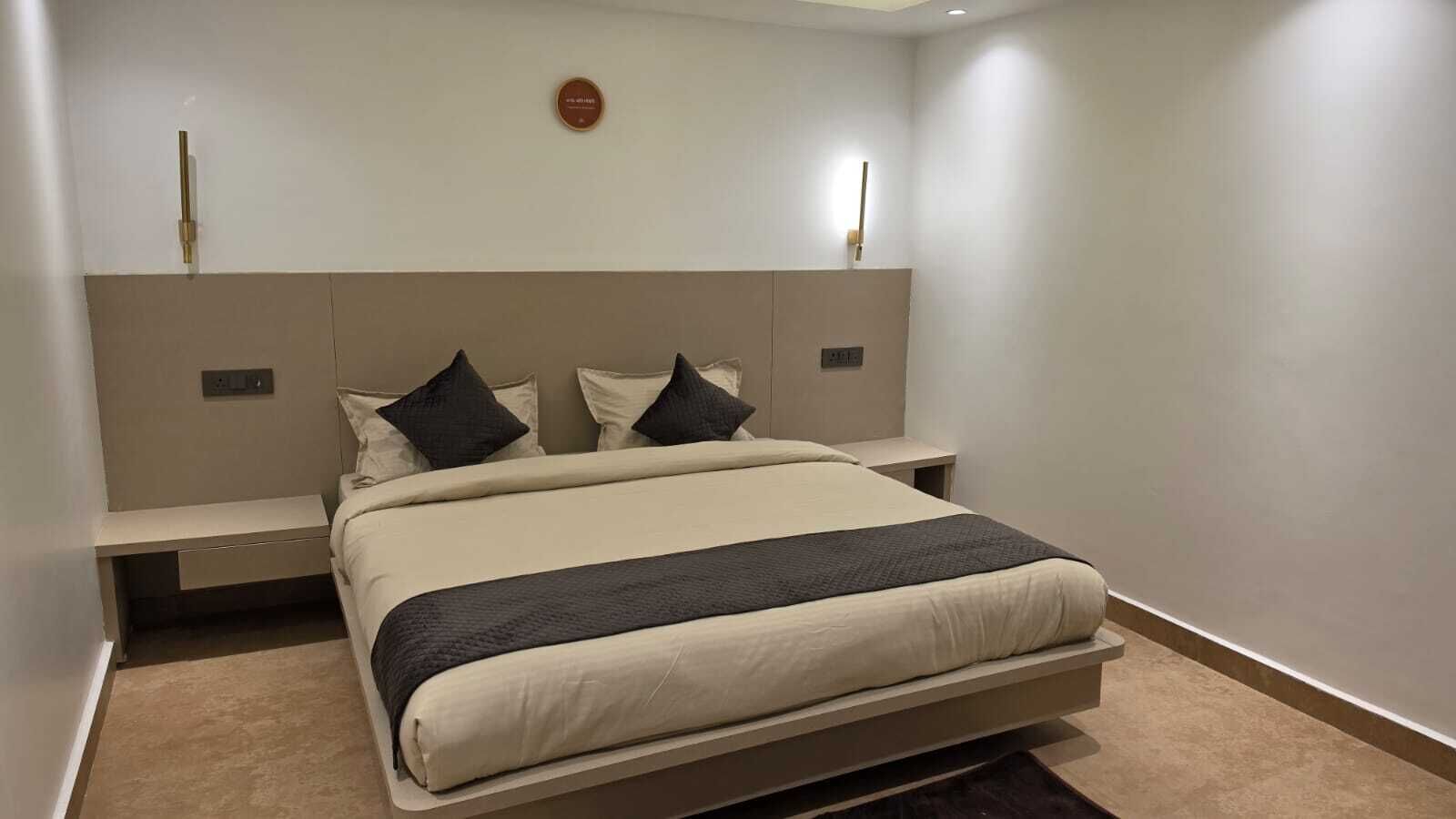 A modern bedroom with a large bed, bedside tables, and a headboard.