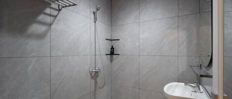 Un baño con ducha, inodoro y lavabo.