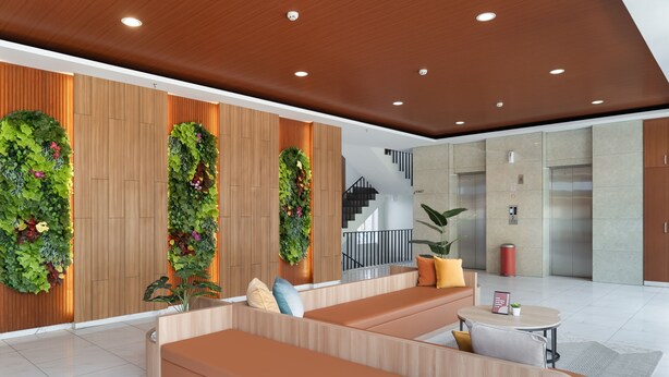 Un vestíbulo moderno con paneles de madera, jardines verticales verdes y un área de descanso con sofás naranja y una pequeña mesa redonda.