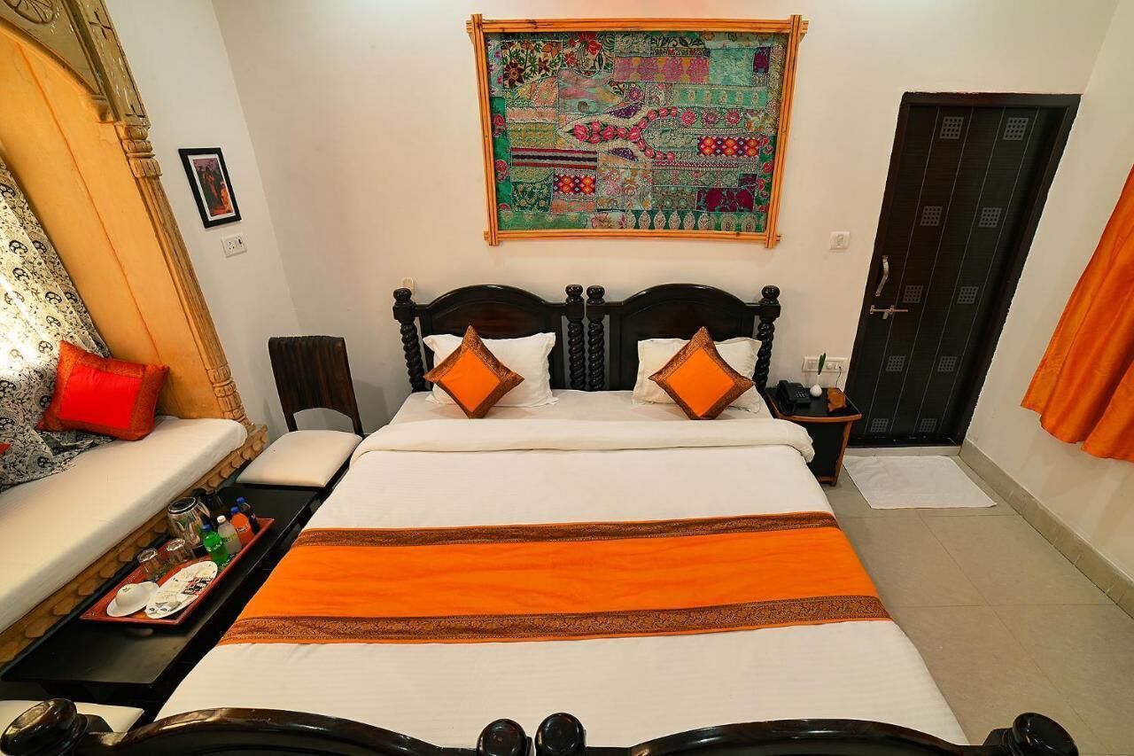 A neatly arranged hotel room with a bed, bedside table, and a wall-mounted artwork.