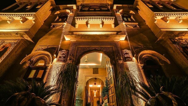 A grand entrance with intricate arches and detailed carvings, leading into a well-lit interior. - Hotel Golden Routes (Jaisalmer)