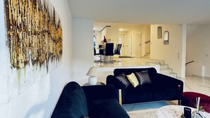 A modern living room with a black sofa, a coffee table, and a painting on the wall. - Quiet Luxury 5BR & 1LR Villa w/ Garden & Terrace (Mödling)