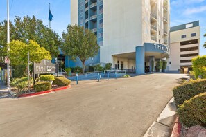 A hotel entrance with a sign for 'Platinum Hotel' and a building with balconies and a flag. - Vegas Condo - Pool, Hot Tub & Balcony Views (Las Vegas)