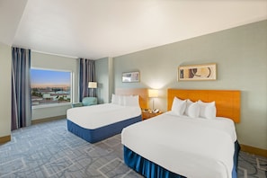 A hotel room with two beds, a city view, a nightstand, and a lamp. - Vegas Condo - Pool, Hot Tub & Balcony Views (Las Vegas)