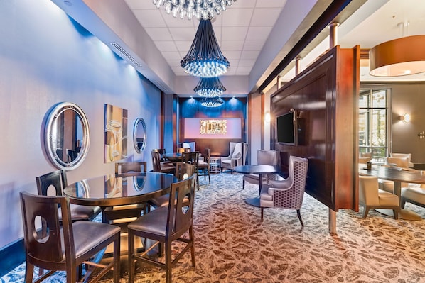 A hotel room with a large bed, a bedside table, a nightstand, a window, and a bathroom with a toilet and sink. - Vegas Condo - Pool, Hot Tub & Balcony Views (Las Vegas)