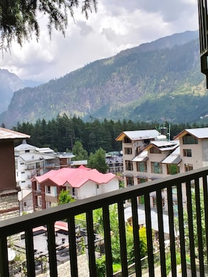 A residential area with houses, a balcony, and a mountain backdrop. - Aavi Grand Manali (Manali)