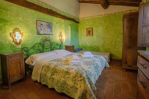 A bedroom with a green wall, a wooden bed frame, a wooden nightstand, and a wooden dresser. - Toskana Family Home With Pool (Siena)