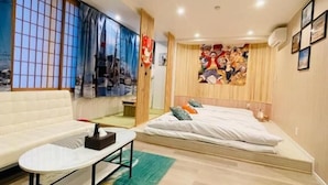 A modern bedroom with a bed, a sofa, a small table, and a large window with a view. - Toei Stays (Nipponbashi Higashi, Naniwa-ku osaka)