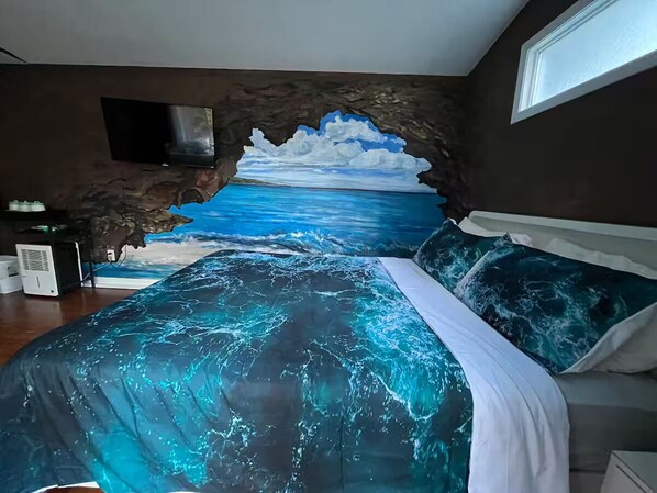 A bedroom with a bed, a TV mounted on the wall, and a window.