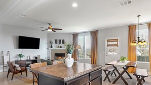Una sala moderna con chimenea, comedor y isla de cocina.