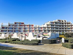 A multi-story hotel with balconies, a gated entrance, and a clear sky. - Les Grenadines by Interhome (La Grande Motte)