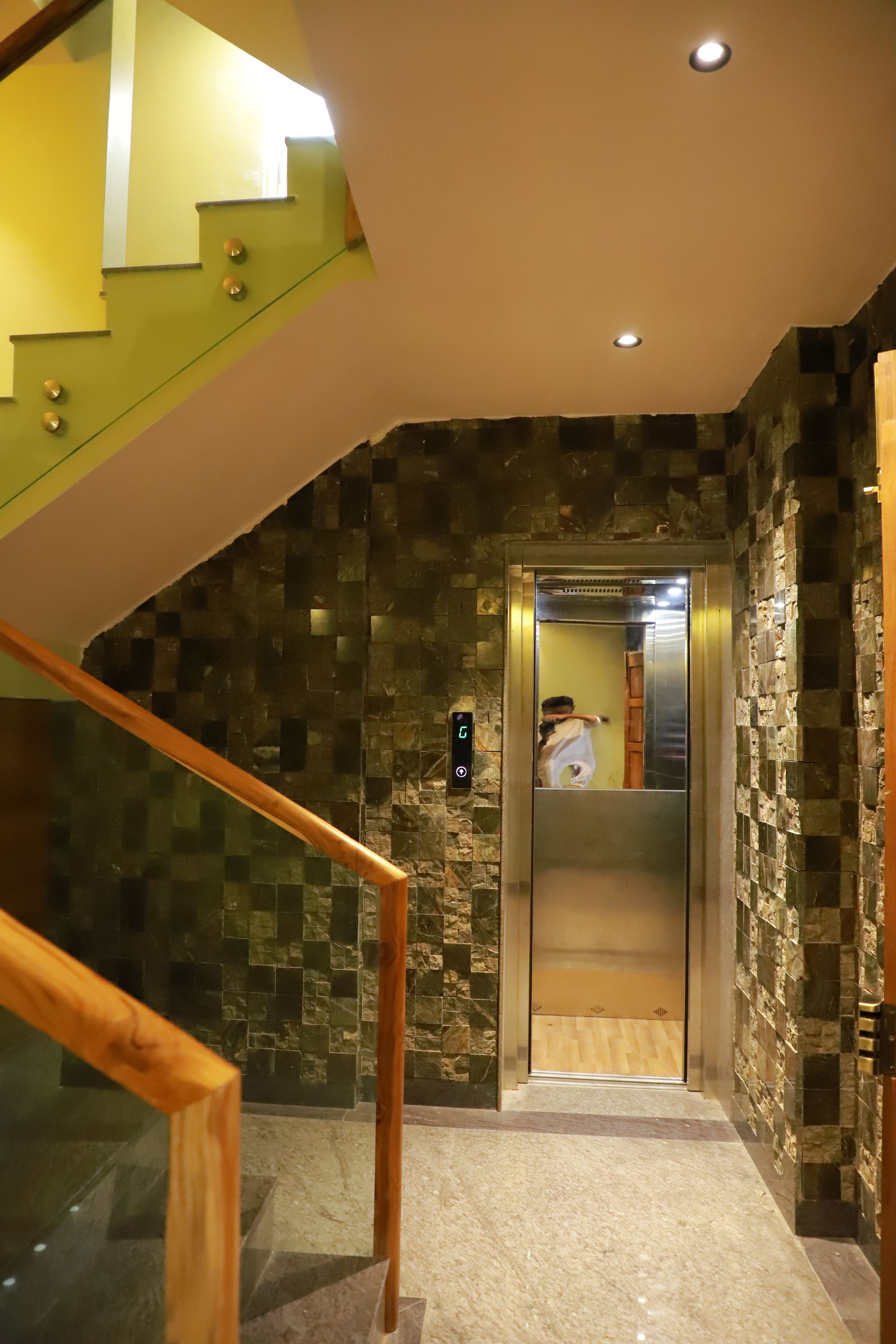 Un interno moderno con una scala, un ascensore e pareti dalla superficie strutturata.