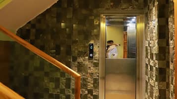 Un interno moderno con una scala, un ascensore e pareti dalla superficie strutturata.