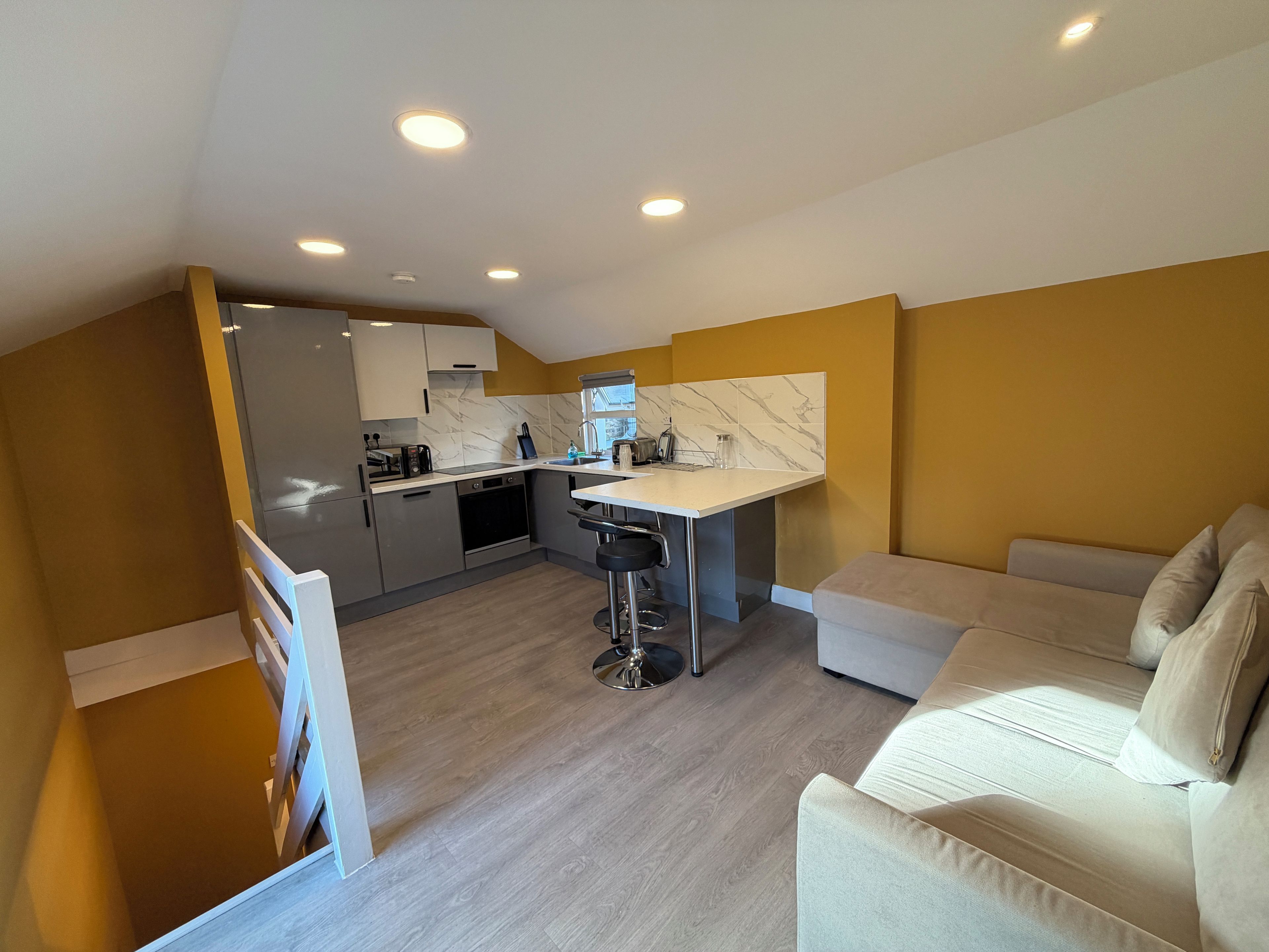 A compact living space with a kitchenette, a dining area, and a sofa.