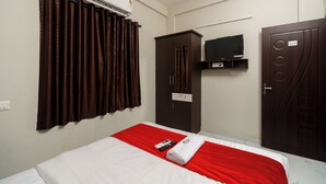Een hotelkamer met een bed, een kledingkast, een televisie en een airconditioning.