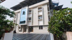 Een meerlaags gebouw met een modern ontwerp, met een opvallende blauwe gevel, meerdere balkons en een verhard entreegebied.