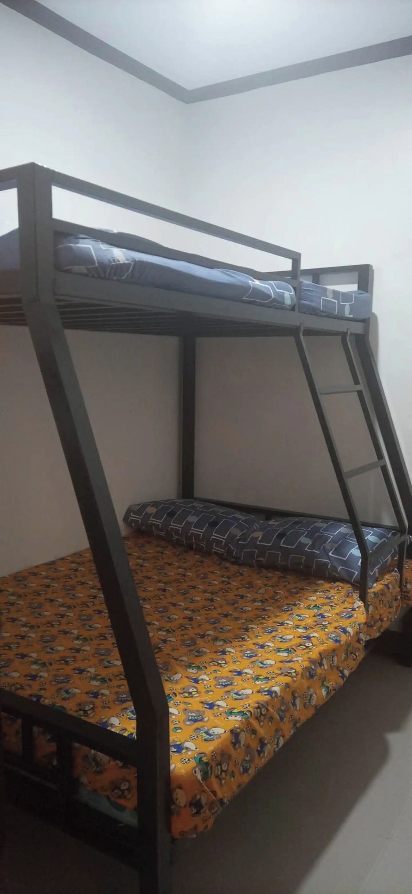 Ein Etagenbett mit gemustertem Bettzeug und einer Stehleiter.