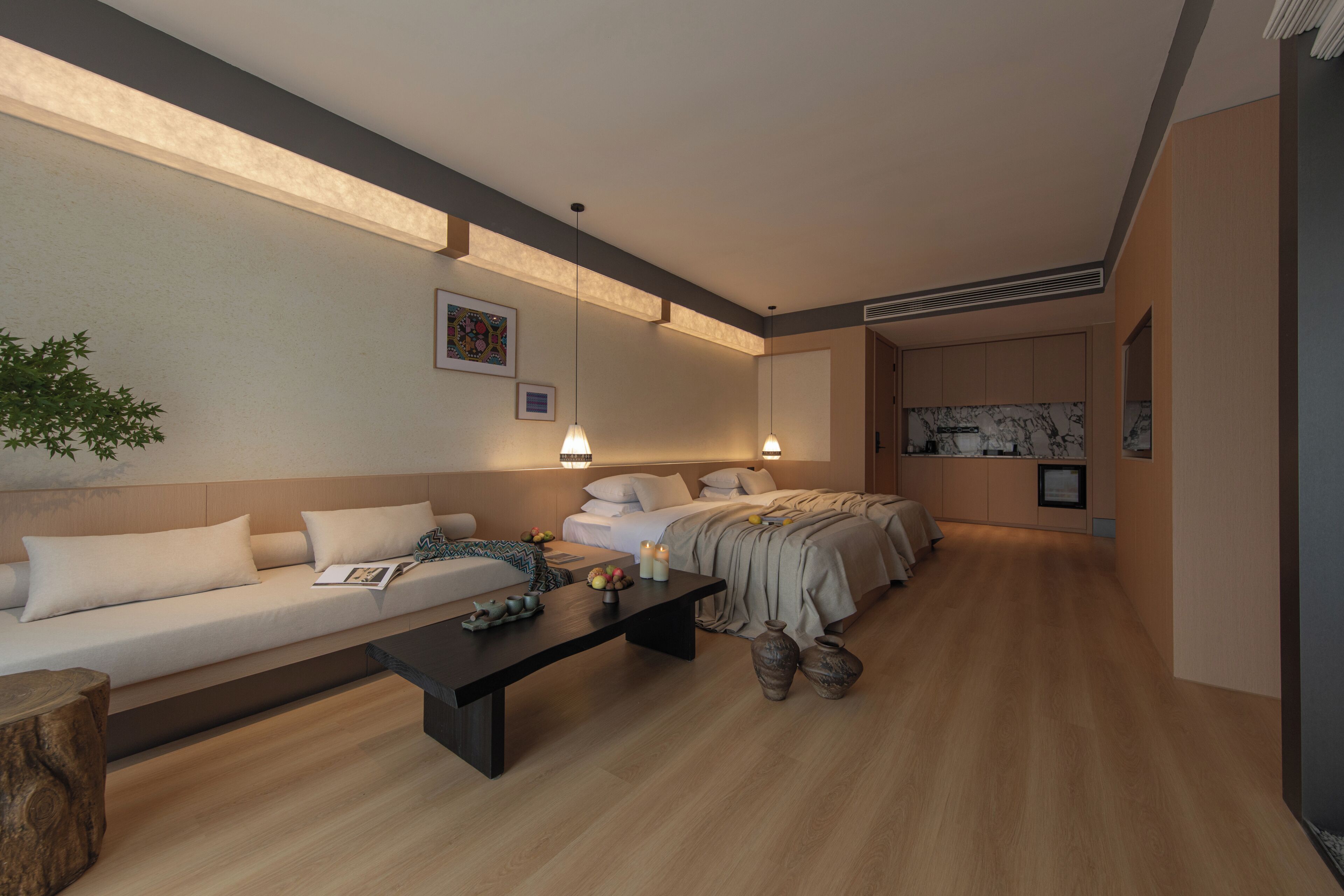 A modern bedroom with a sofa, a bed, a bedside table, and a nightstand.