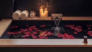 A room with a large window overlooking a mountainous landscape, a small indoor water feature with rose petals, and a shelf with towels and candles. - L'Eau Vive de Qixi Meidi Yangshuo- Riverfront Infinity Pool & Log Cabin Cafe (Guilin)