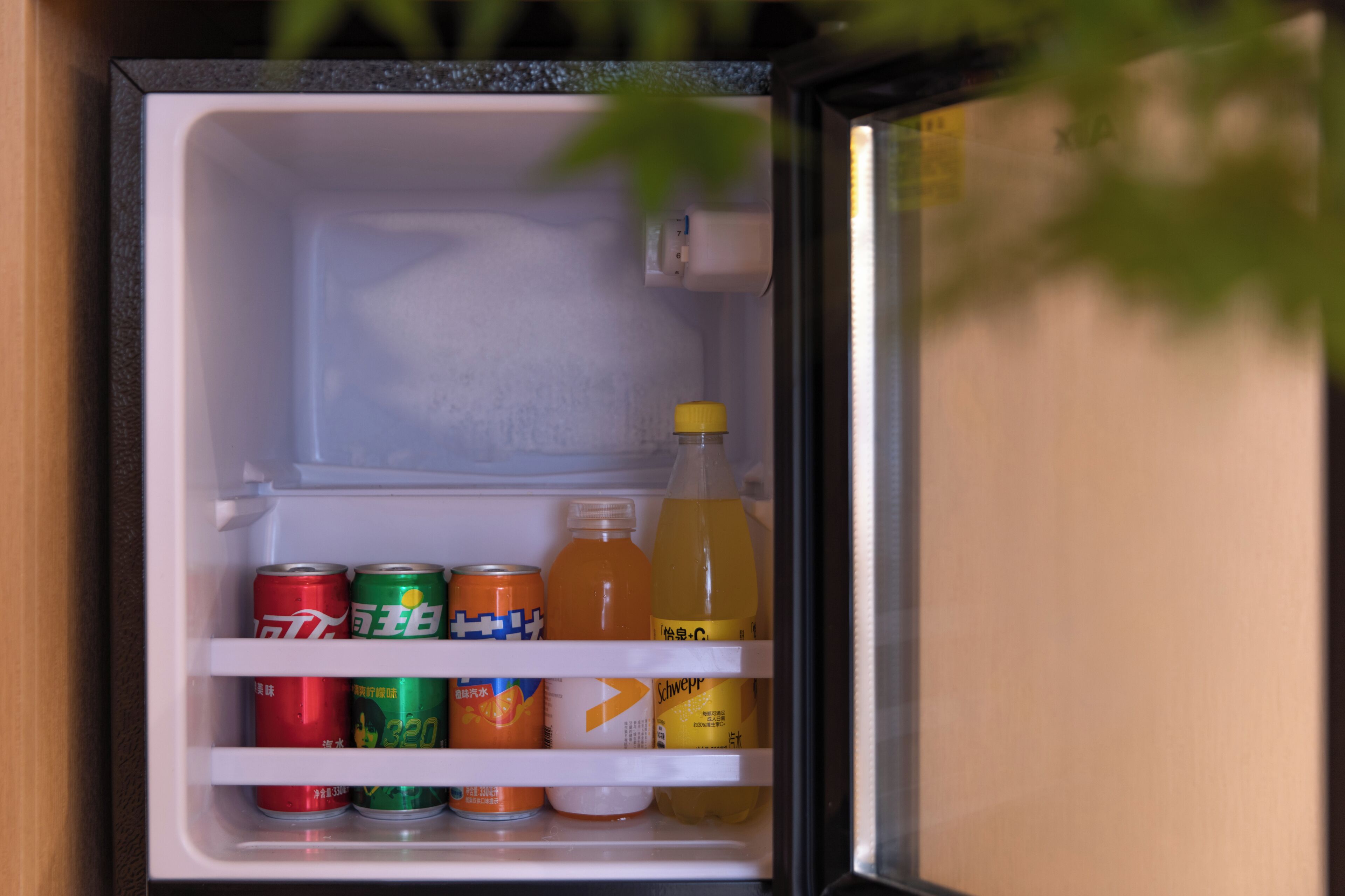 Un réfrigérateur ouvert contenant des boissons et des canettes.