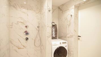 Een douche, handdoeken, zeep, toiletpapier