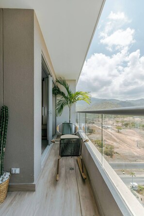 Ein Balkon mit Blick auf eine Wüstenlandschaft, einem Kaktus und einem Stuhl.