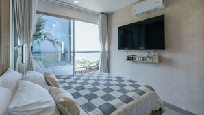 A hotel room with a bed, a TV mounted on the wall, an air conditioning unit, and a balcony with a view. - Modern Loft Beachfront,airport,wife Santa Marta (Santa Marta)