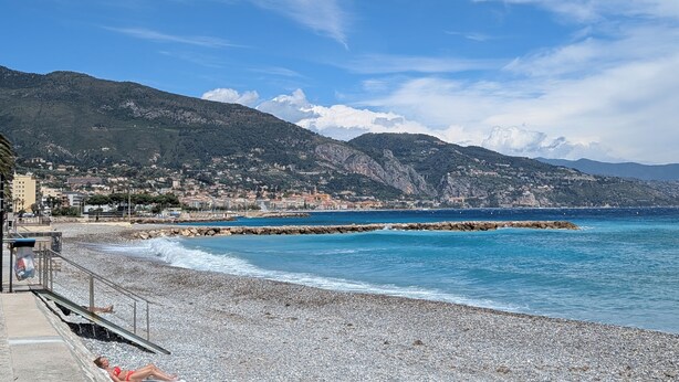 A coastal town with a pebble beach, a pier, and mountains in the background. - Fully furnished apartment, beaches, between Monaco and Menton (Roquebrune-Cap-Martin)