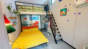 Un dormitorio pequeño con una cama nido, un escritorio, una escalera y un aire acondicionado instalado en la pared.